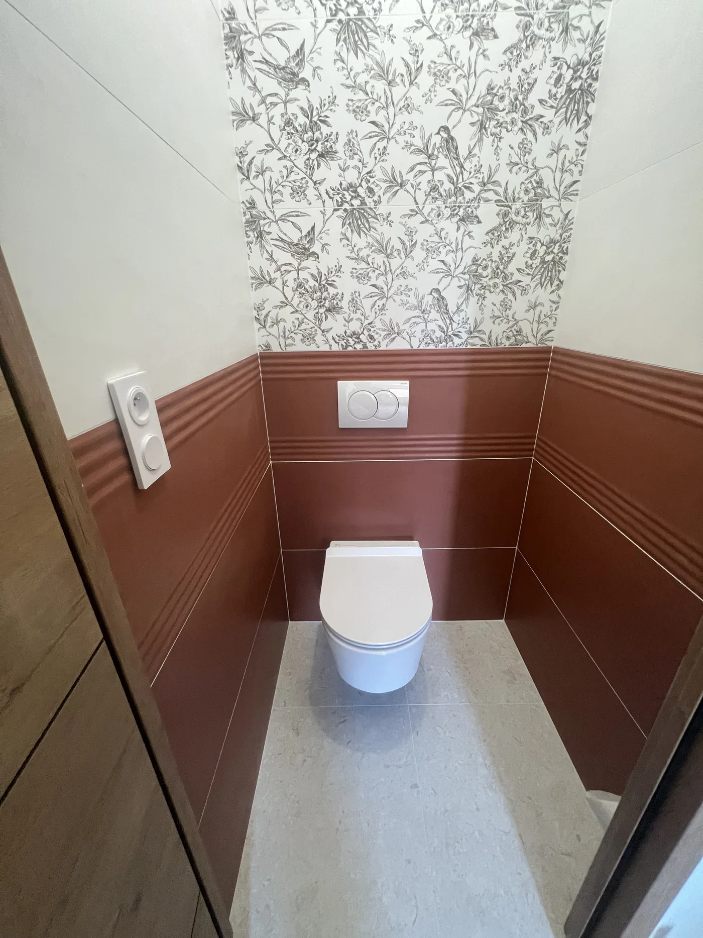 WC suspendu à Nantes : bâti-support avec plaque de commande Geberit, faïence terracotta en partie basse et faïence décor à motif en partie haute, raccord de motif dans l angle